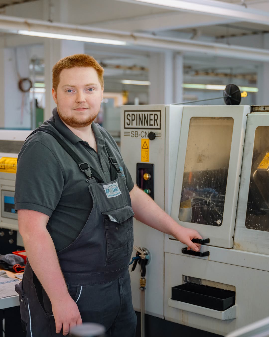 Mitarbeiter bedient CNC-Drehmaschine in der Fertigung