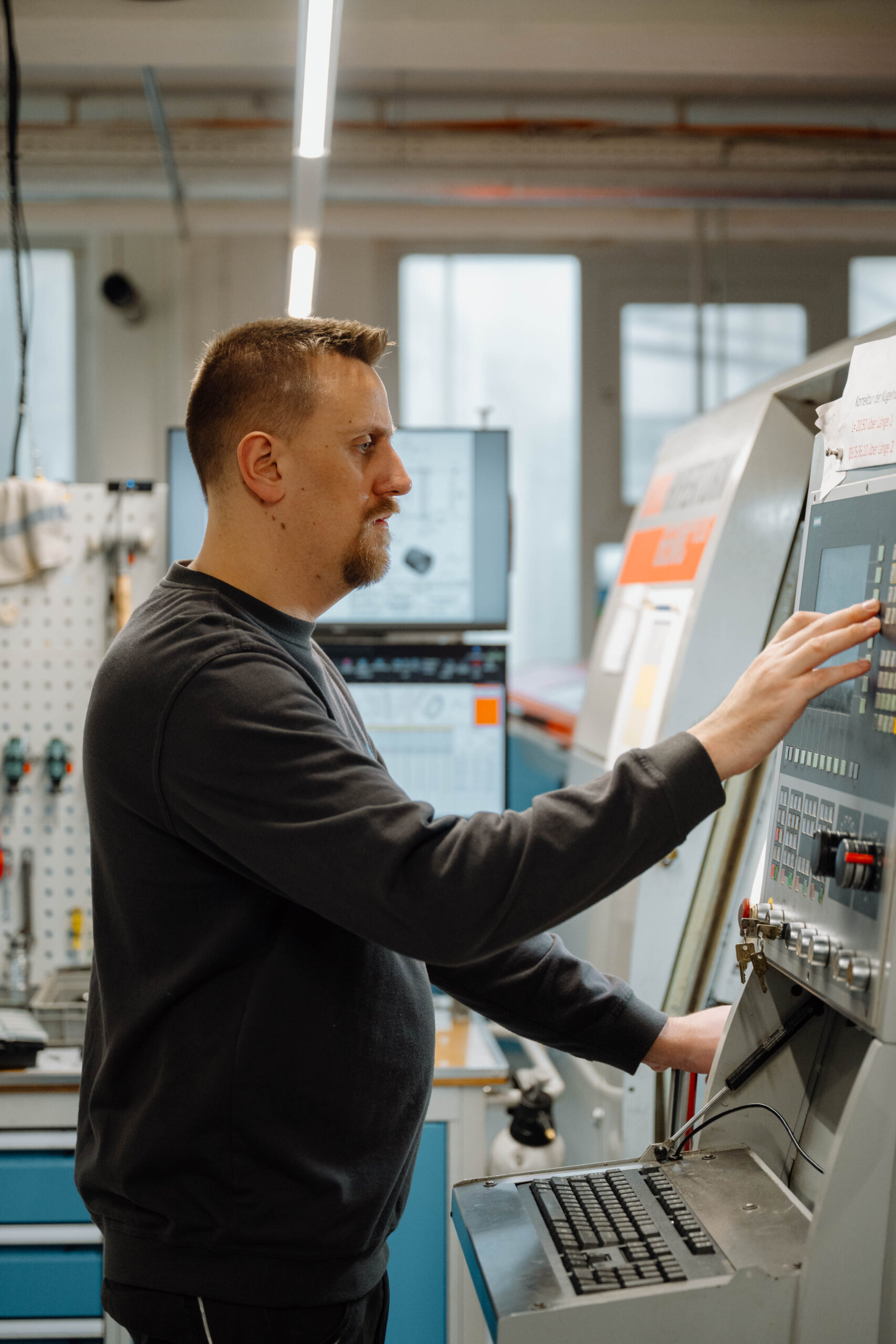 Mitarbeiter bedient CNC Maschinensteuerung