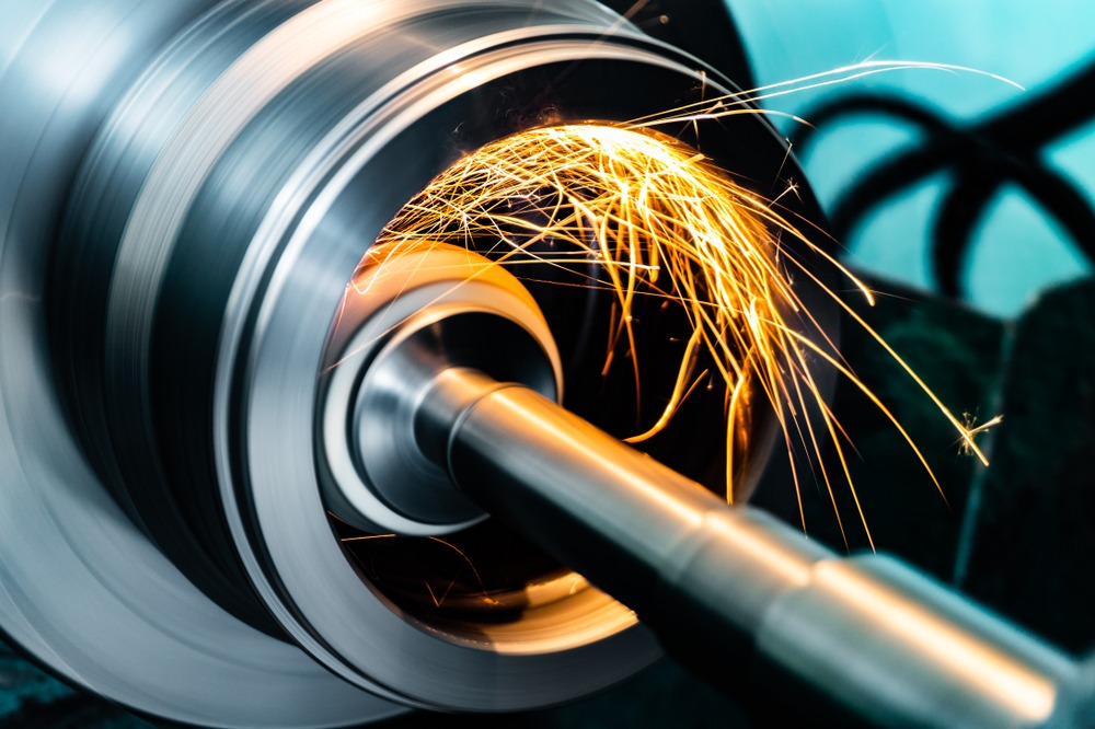 Metall schleifen: Funkenflug bei der Metallbearbeitung eines CNC Bauteils